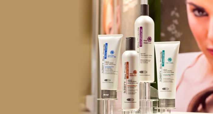 Four ICON hair care products displayed on a shelf with a woman's face partially visible in the background.